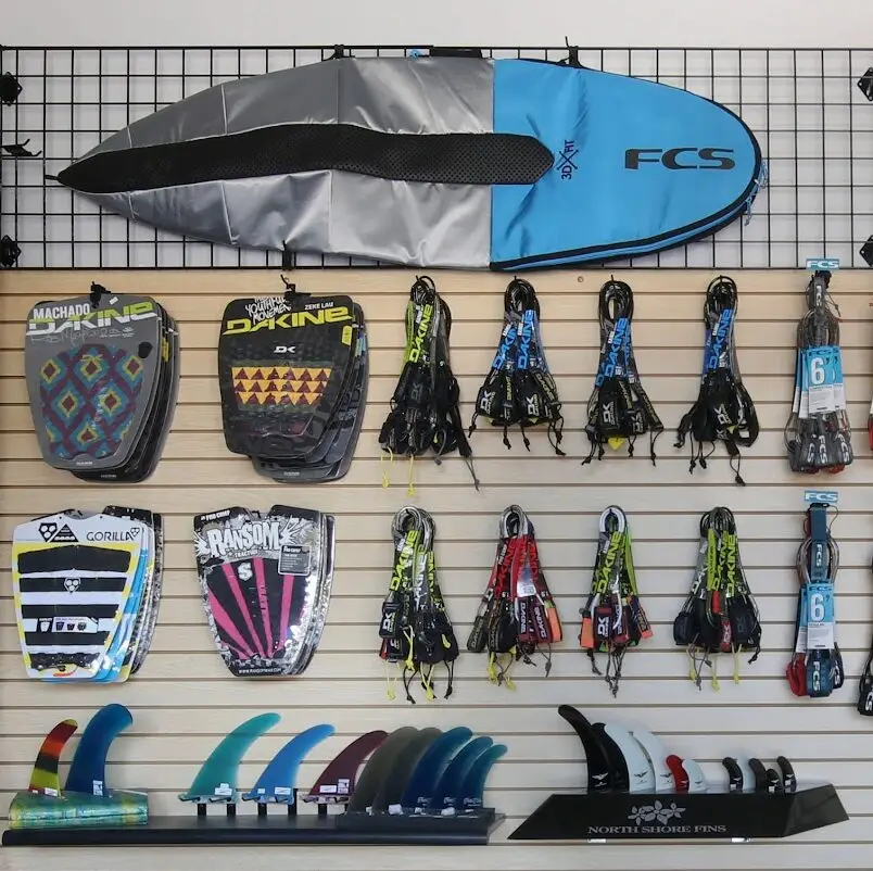 Surfing supplies such as stomp pads, surf leashes, surfboard travel bags, and fins at the Roper's shop.